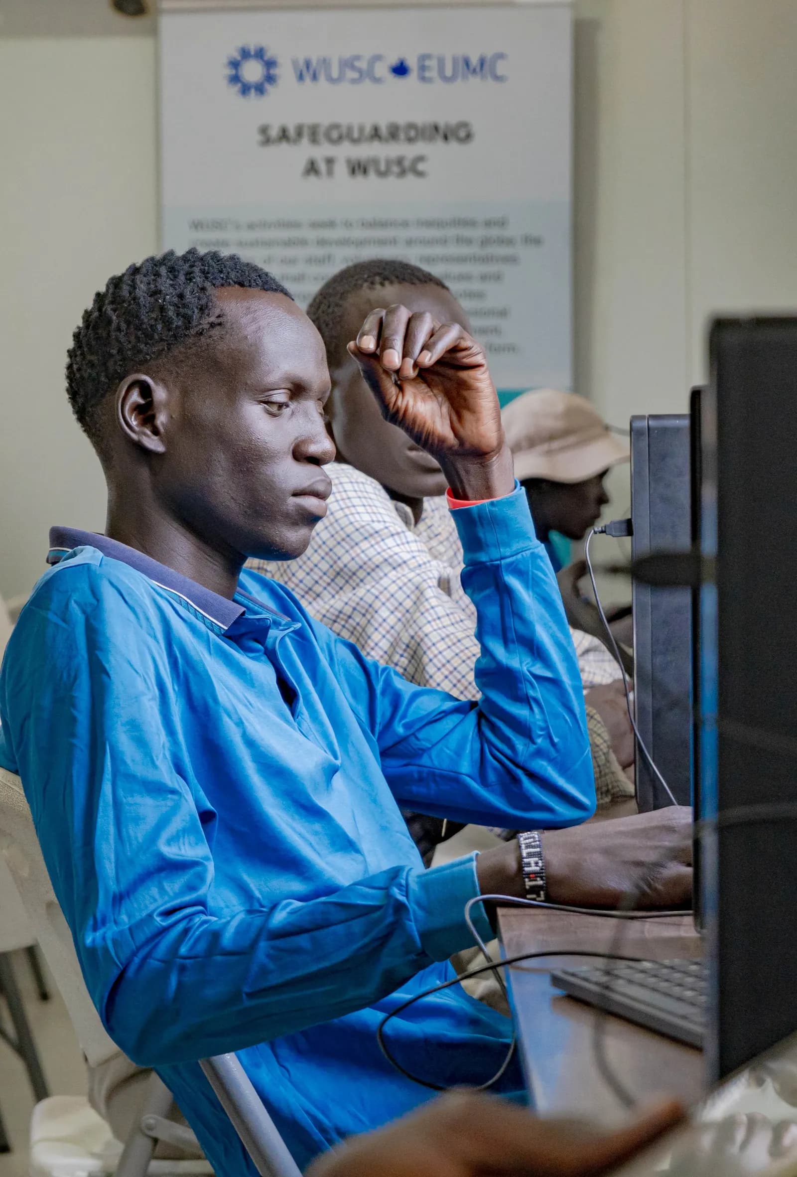 Refugee developer working at desktop computer during Day 2 sprint